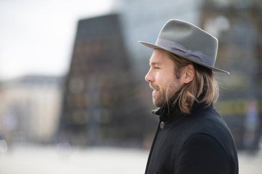 man with hat, coat and beard outside walking