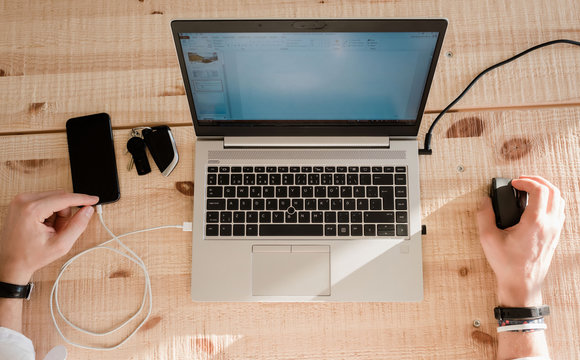 Sky View Of A Man Working From Home With His Phone And Laptop