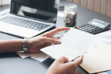 Accountant hands holding saving account passbook, book bank.