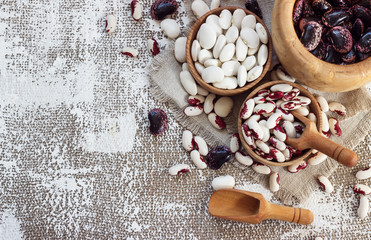 colored beans in wooden cups on a light background