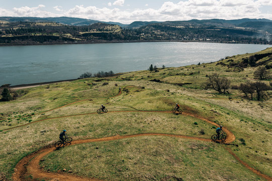 A group of girls bike along a trail overlooking the Columbia River.