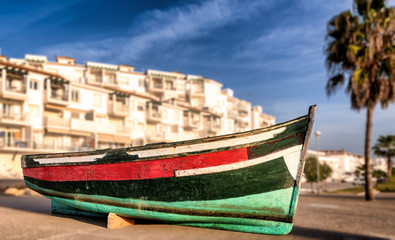 Fototapeta na wymiar Small boat placed facing the sea in Conil de la Frontera, Cadiz, remembers those immigrants who lost their lives trying to reach the coast of Spain; selective focus.
