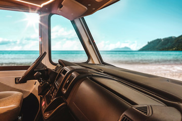 Summer car interior of camper and beach landscape with ocean.
