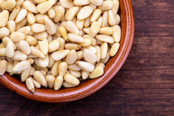 Peeled pine nuts. Aerial view (from above, top view). Foreground (Close-up). Wood background Rustic, natural and homemade appearance.