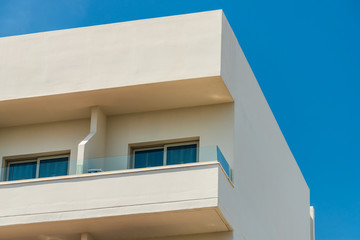Modern new building with open balconies against the summer blue sky