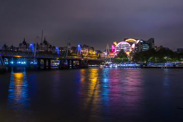 Fototapeta na wymiar Night London Charing Cross station and Hungerford Bridge, reflection night lights. London, UK.