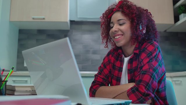 Happy girl in headphones having conference call on laptop, taking online classes