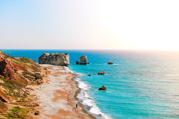 Seashore and pebble beach with wild coastline by Petra tou Romiou in Cyprus island, Greece