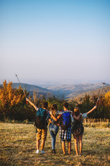 adventure, travel, tourism, hike and people concept - group of smiling friends walking with backpacks in nature