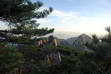 Keuken foto achterwand Huangshan Huangshan Mountain in Anhui Province, China. View at sunrise from Dawn Pavilion viewpoint with a rocky outcrop and pine trees. Scenic view of peaks with foreground trees on Huangshan Mountain, China.