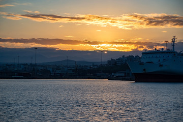 Golden sunrise over Heraklion harbour, Crete with peaceful sea and bih ship.