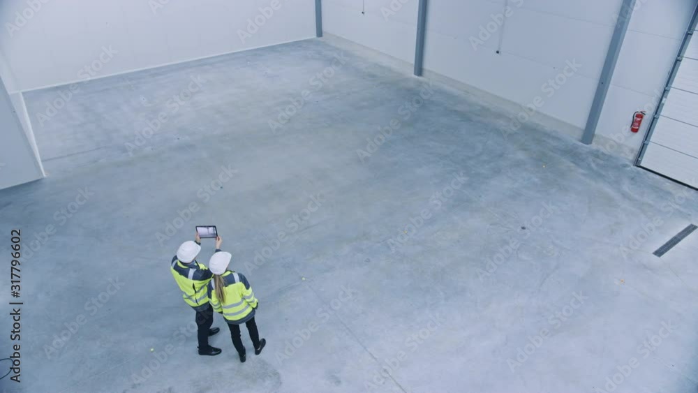 Aufkleber Industry 4.0 Modern Factory: Two Engineers Use Digital Tablet Computer with Augmented Reality Software Visualizing of Manufacturing Plant Room Mapping. Doing 3D Factory Floor Layout. High Angle Shot