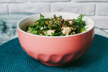 Diet menu. Healthy salad of fresh vegetables - tomatoes, avocado, ruccola, radish and seeds on a bowl. Vegan food.