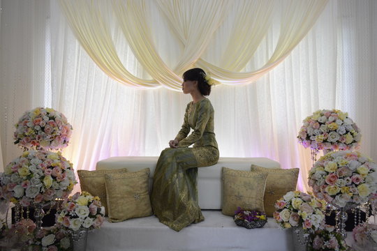 Full length of bride sitting on couch amidst flowers during wedding