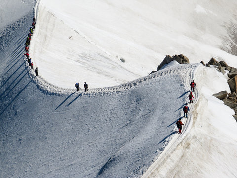 High angle view of hikers walking on snowcapped mountain