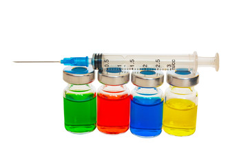The syringe lies on the vessels with colored liquid.