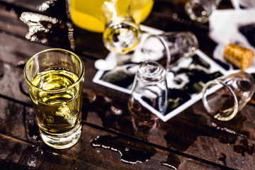 alcoholism and divorce. Fallen drink glasses on wooden table, torn family photo. Concept of divorce and addiction problems with drinking.