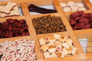 Pet food, snacks for dogs. Dog tasty colored biscuits on wooden background