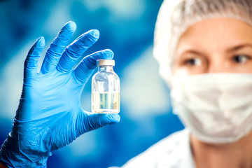 A doctor holding a bottle with vaccine. Medicine and healthcare