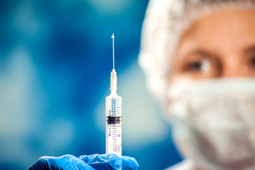 A doctor holding a bottle with vaccine. Medicine and healthcare concept