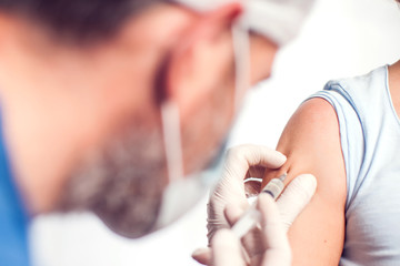 A doctor doing injection to the patient. Isolated. Medicine and healthcare concept