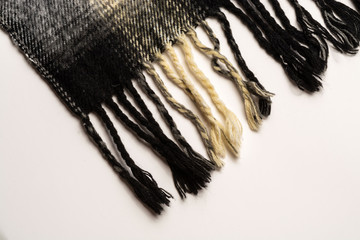 A close-up of a fragment of the fringe scarf is brown black. Diagonal location