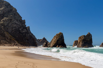 Scenic view of rugged and dramatic coastline with huge boulders at the Praia da Ursa beach near Cabo da Roca, the westernmost point of mainland Europe, in Portugal.