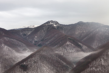 Soft, misty, ethereal scene of amazing pyramidal shapes of mountain highlands covered by forest...