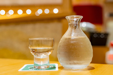 Close up shot of a bottle and a cup of cold Sake