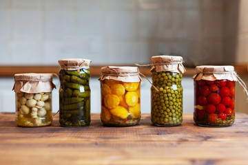 Pickled patissons, cucumbers, mushrooms, green pea and tomatoes canned into glass jars. Ingredients...