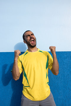 Young man sporting Brazilian football team. Cheering and Celebrating.
