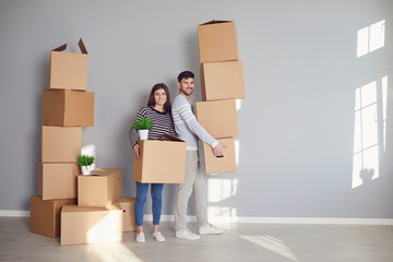 Young couple family with boxes to move in a new house room.