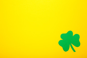 Happy Saint Patrick's of handmade paper clover leaf on yellow background.