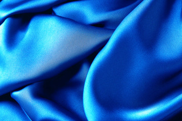 Blue sapphire color silk fabric background, top view.