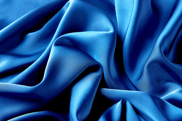 Blue sapphire color silk fabric background, top view.