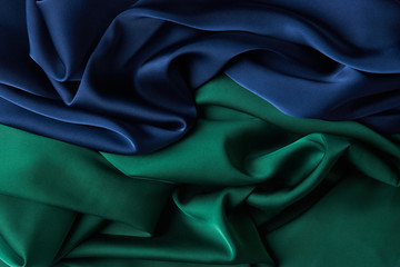 Blue and green color silk fabric background, top view.