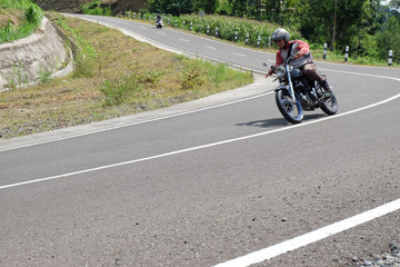 Man riding a classic motorcycle on highway of mountain