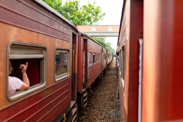 People communicate from the windows of various trains stopped at the station