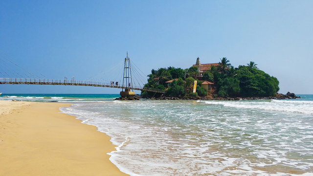 Bridge from the beach to the island in the ocean
