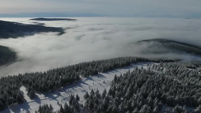 Aerial view of winter in mountains - trees covered with snow. Aerial photography of snowy hilly forest. Captured from above with a drone.