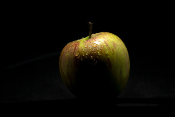 Fresh green apple closeup over black background