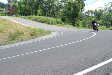 Fototapeta na wymiar Man riding a classic motorcycle on highway of mountain