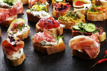 Assorted bruschetta with various toppings. Appetizing bruschetta or brie crostini. Variety of small sandwiches. Mix bruschetta on table