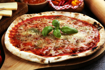 Pizza with tomatoes, mozzarella cheese, basil. Delicious italian pizza on wooden pizza board.