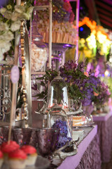 A sweet table with desserts and sweets in purple colors. Decor luxury wedding celebration.
