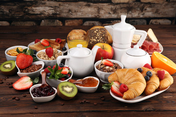 Breakfast served with coffee, orange juice, croissants, cereals and fruits. Balanced diet. Continental breakfast with granola and fruits