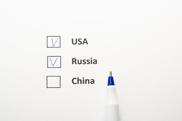 USA, Russia - checkbox with a tick on white paper with blue pen.