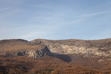 Rocky peaks and vivid autumn colors of the forest on Svrljig (Svrljiske) mountains in Serbia under a clear blue sky