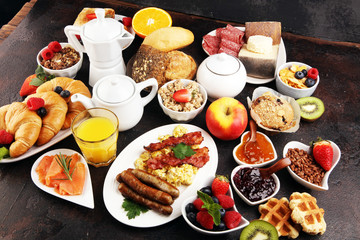 Breakfast served with coffee, orange juice, croissants, cereals and fruits. Balanced diet. Continental breakfast with granola and fruits