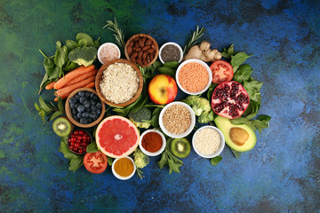 Obraz na płótnie Canvas Healthy food clean eating selection: fruit, vegetable, seeds, superfood, cereals, leaf vegetable on rustic background